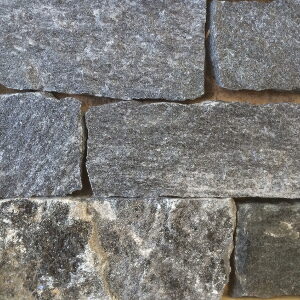 Close-up swatch of dark gray mica-flecked stone veneer blocks.