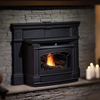 Black cast-iron gas fireplace insert with arched glass door on a stone hearth