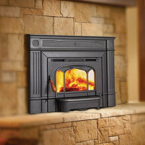 Black cast-iron wood-burning insert with glass doors in a stacked stone surround