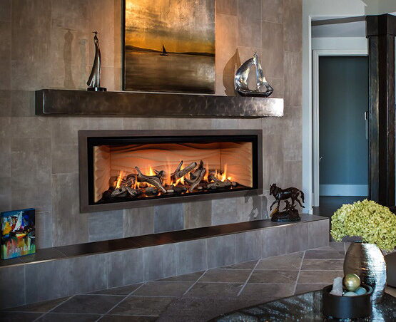 Linear gas fireplace in a tiled wall with a floating metal mantel shelf and art