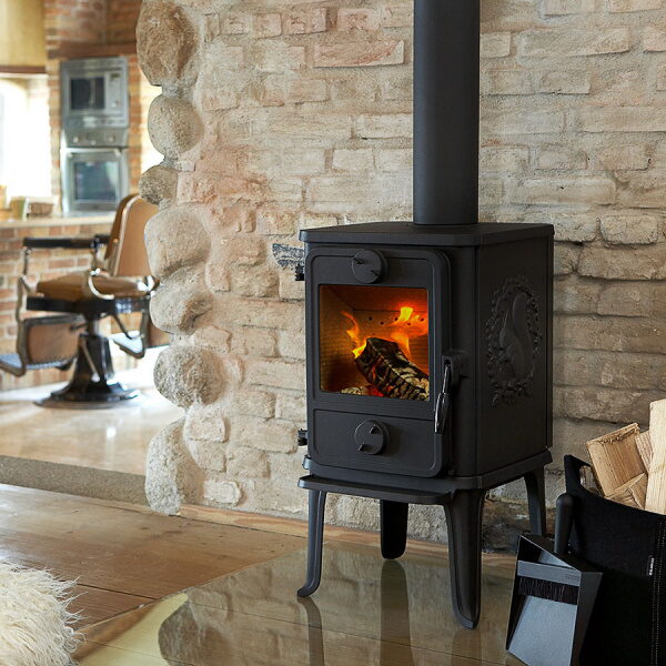 Small black Morso wood stove on a stone hearth in a brick-walled room