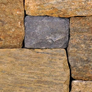 Close-up of tan, gray, and purple squared stone wall texture