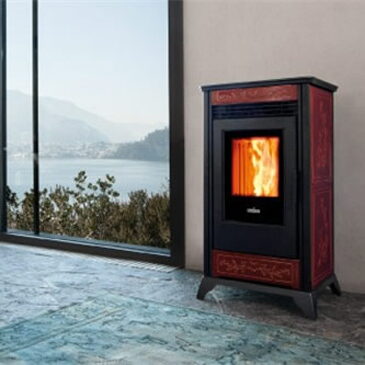 Red and black Ravelli pellet stove beside a window overlooking a lake