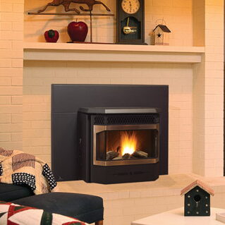 Black pellet stove insert set into a cream brick fireplace with a decorated mantel