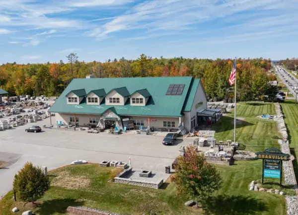 Aerial view of the Granville Stone and Hearth store building with a green roof and parking lot in fall