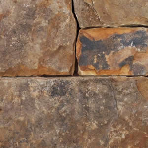 Close-up of orange, brown, and black squared stone wall texture