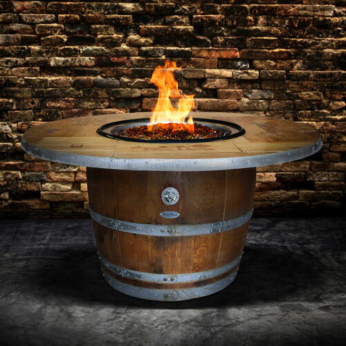 Round gas fire pit table built from a wine barrel with metal banding and flames in the center.