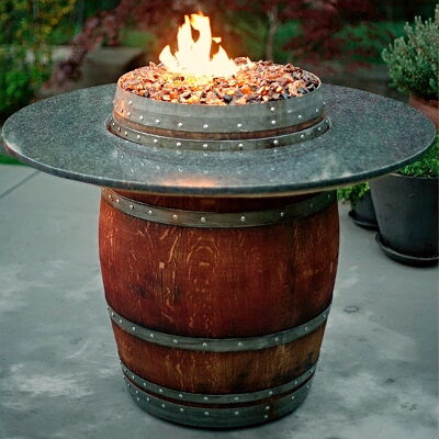 Wine barrel gas fire pit table with a galvanized metal rim and lit flames