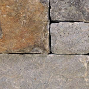 Close-up of squared gray and rust-toned stone veneer blocks.